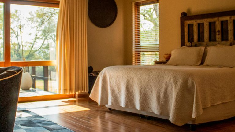 Inviting rustic bedroom in a cabin with natural light and cozy decor.